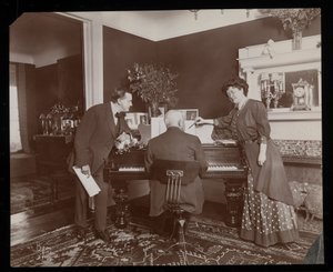 Clara De Regand, bir adam piyano çalarken bir notayı işaret ediyor, 1910 (gümüş jelatin baskı)